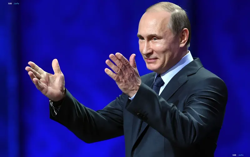 Президент России Владимир Путин выступает на сцене с жестикуляцией руками