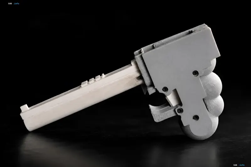 Homemade 3D-printed WASP pistol in gray with a plastic frame and metal parts on a black background