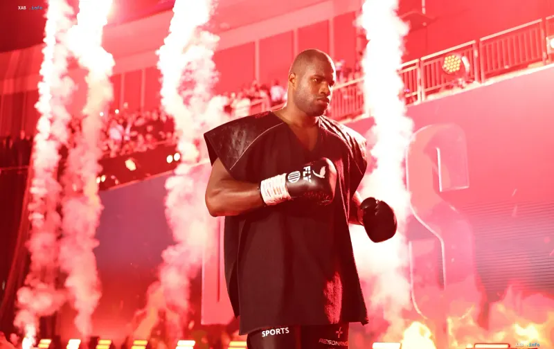 Daniel Dubois in schwarzer Kleidung und Boxhandschuhen unter rotem Licht in der Arena