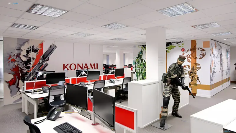 Modern Konami office with workstations and a statue of Solid Snake