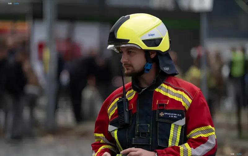 A firefighter in a protective helmet and uniform amid the aftermath of a nighttime attack in Irpin