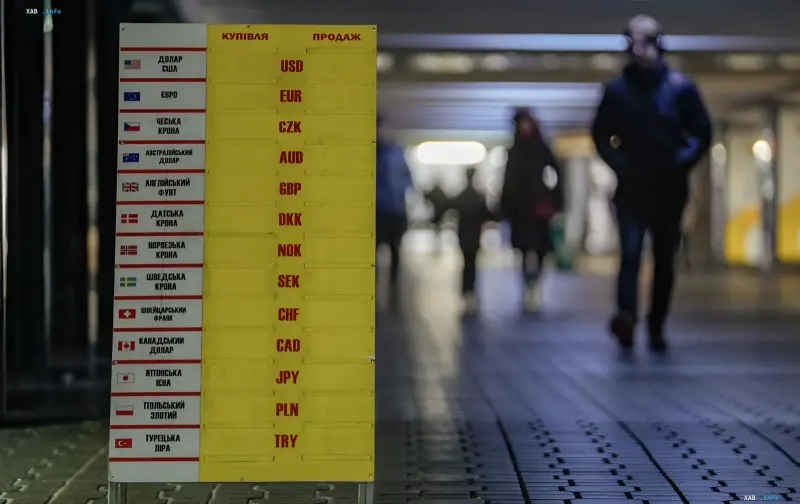 Wechselkurstafel in einer Unterführung mit den Silhouetten von Passanten