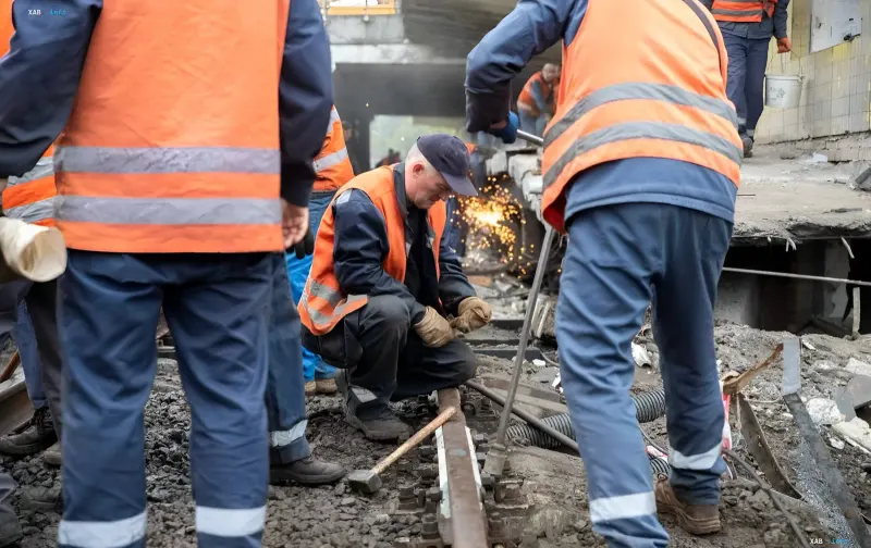 Ремонтные бригады в оранжевых жилетах проводят восстановительные работы на поврежденных железнодорожных путях в Киеве