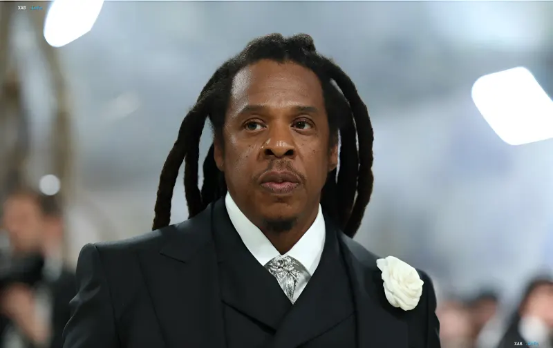 Der amerikanische Rapper Jay-Z in einem schwarzen Anzug mit einer weißen Blume im Revers