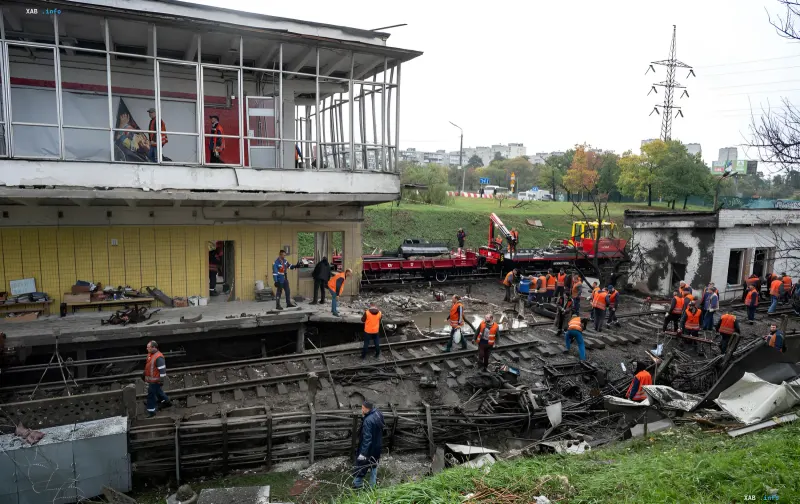 Repair crews in orange vests work on damaged tracks at Chernihivska metro station in Kyiv