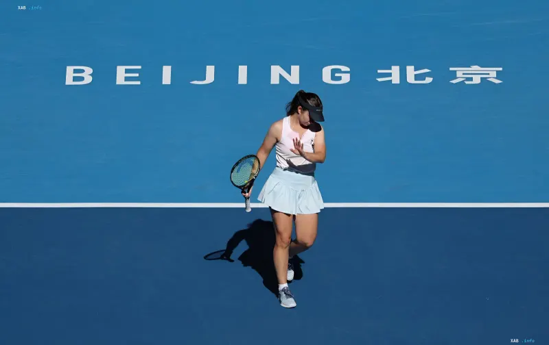 Теннисистка грустно идет по синему корту на турнире WTA в Пекине