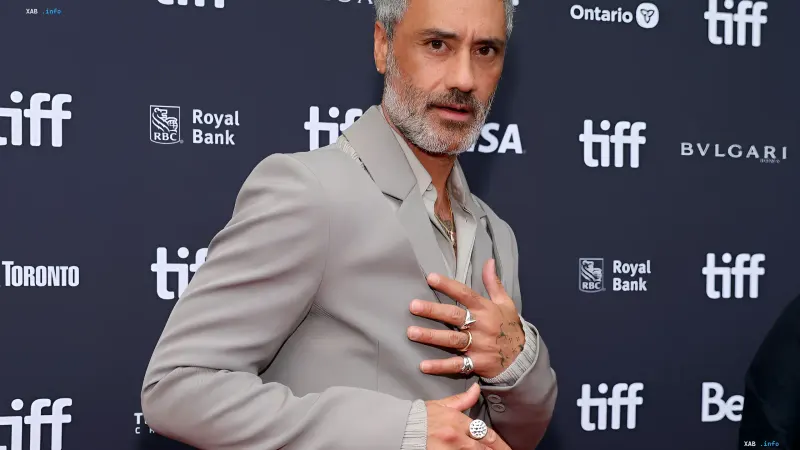 Regisseur Taika Waititi in einem eleganten grauen Anzug auf dem roten Teppich eines Filmfestivals