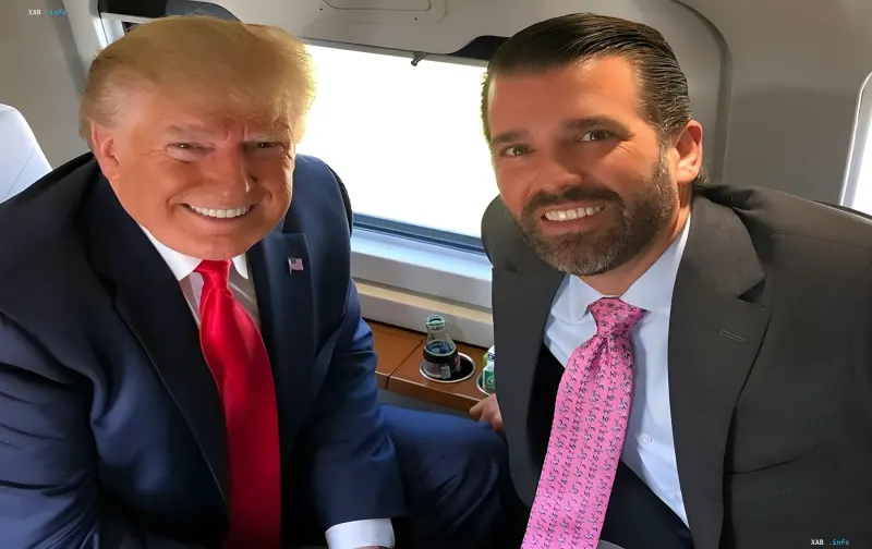 Дональд Трамп і Дональд Трамп-молодший сидять у салоні літака та посміхаються