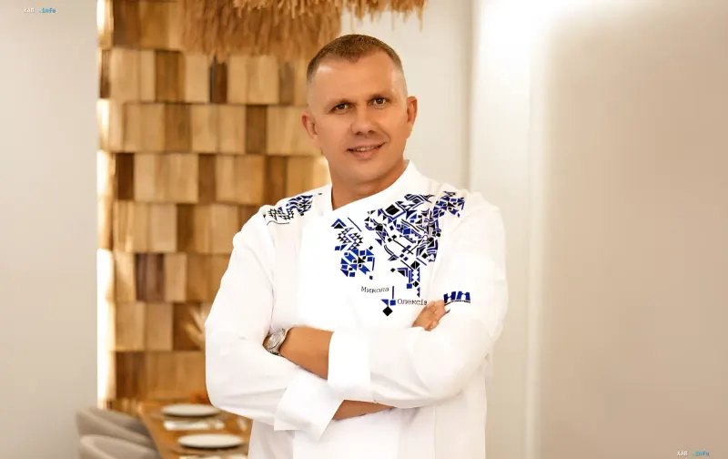 Ukrainian restaurateur Mykola Oleksiv wearing a white chef's coat with traditional patterns