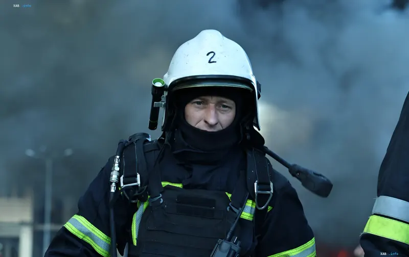 Firefighter in protective gear and white helmet against smoke background