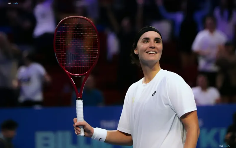 Angelina Kalinina joyfully holding a tennis racket on the court after a successful season