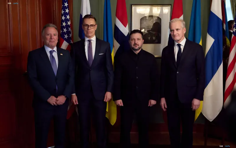 Volodymyr Zelenskyy and political leaders at an official meeting against the backdrop of state flags