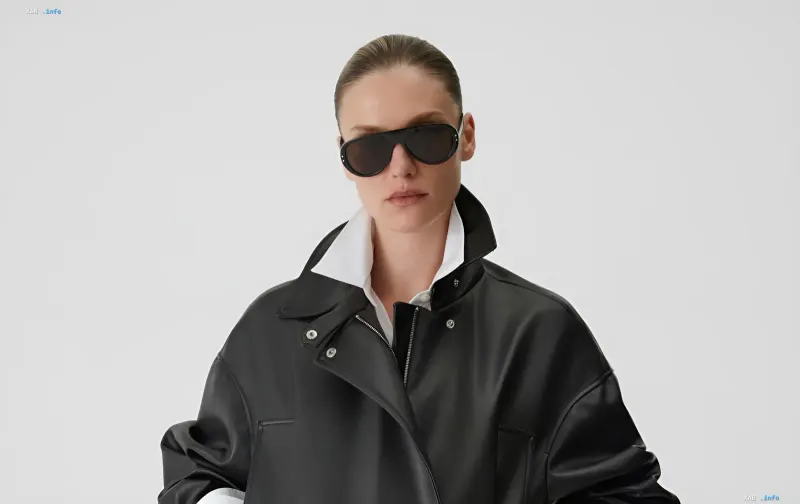 Model wearing sunglasses and a black leather jacket over a white shirt