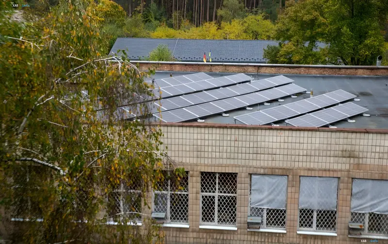 Solar panels on the roof of a social nursing home in Kyiv surrounded by trees