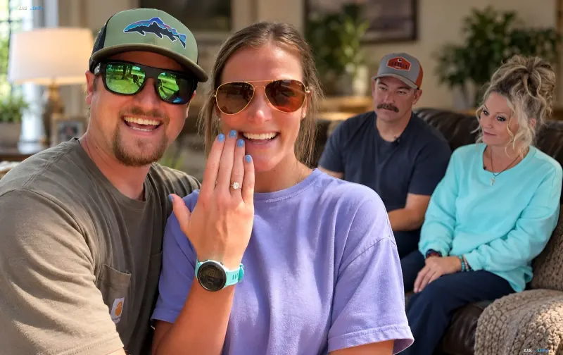 Happy couple showing an engagement ring with random plane passengers sitting in the background