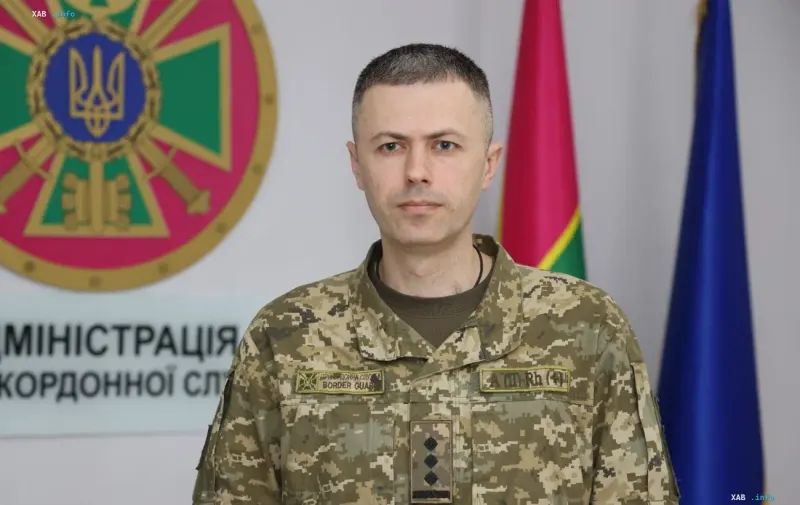 Спикер Государственной пограничной службы Украины Андрей Демченко в военной форме на фоне государственной символики
