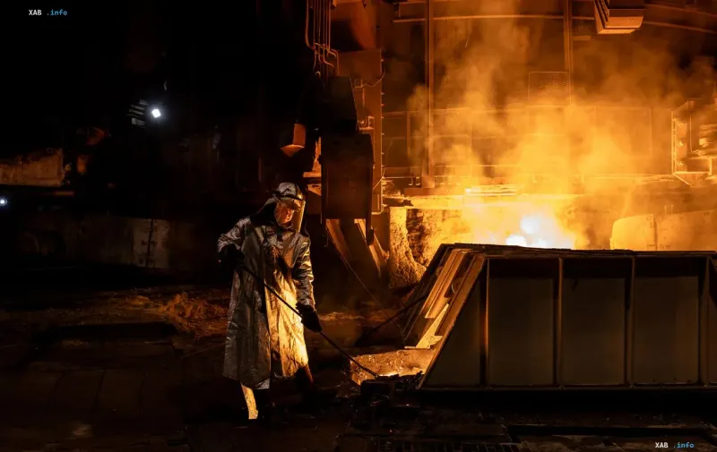 Worker in protective suit near a furnace at a metallurgical plant in Ukraine