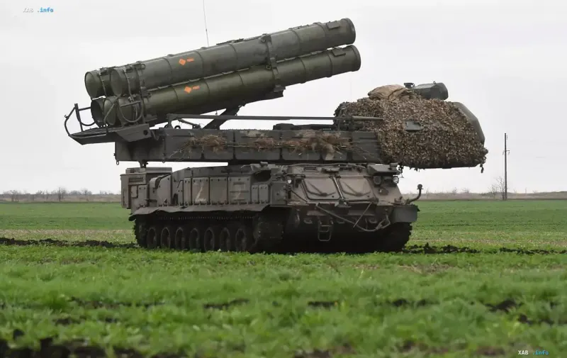 Russisches Flugabwehrraketensystem Buk auf Kettenfahrgestell in einem Feld während militärischer Operationen