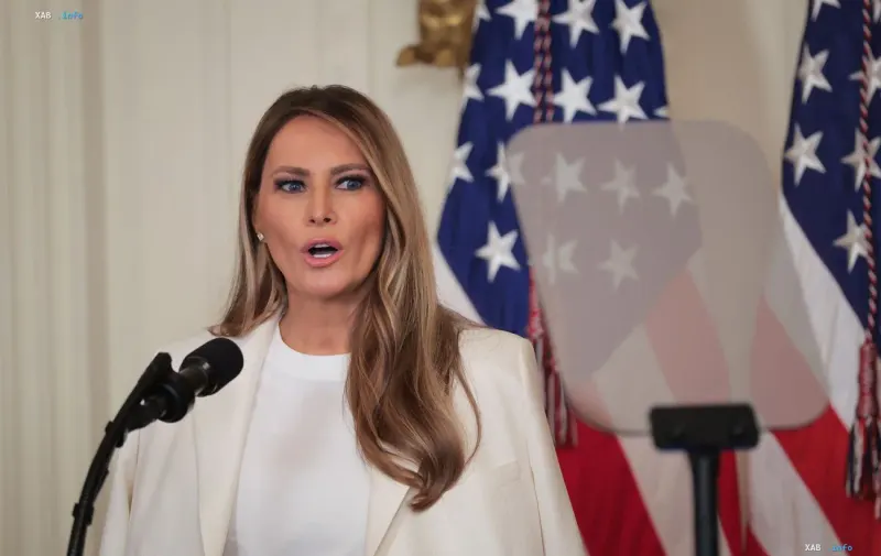 Перша леді США Меланія Трамп виступає під час офіційного заходу на тлі американських прапорів