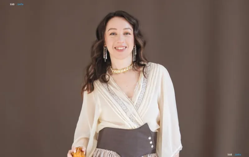 Ukrainian bandurist Anastasiia Voitiuk smiling in a light blouse against a neutral background