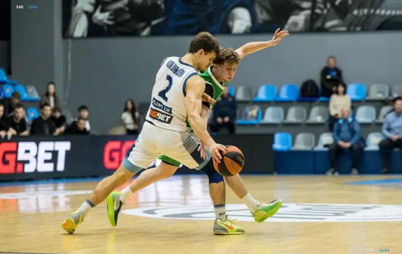 Two basketball players fight for the ball during a Ukrainian Superleague match in an indoor arena