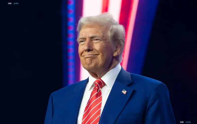US President Donald Trump speaking during a public event against blue and red decorations