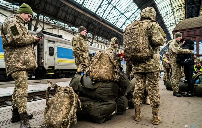 Ukrainische Soldaten mit Rucksäcken auf einem Bahnsteig vor der Abfahrt