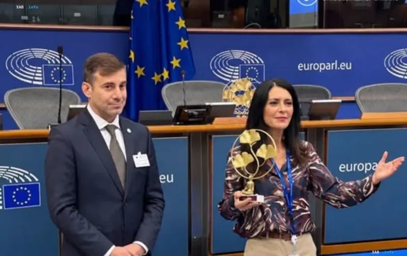 European Parliament Vice-President Pina Picerno holding an award alongside a colleague in the European Parliament hall