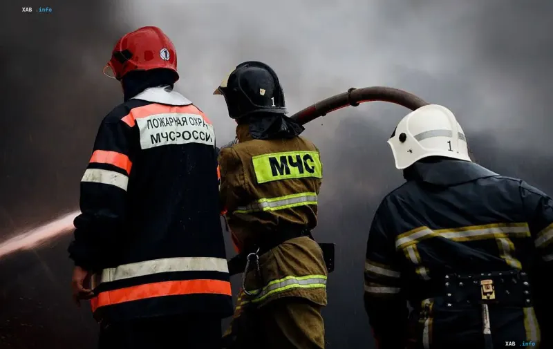 Feuerwehrleute des Katastrophenschutzes bekämpfen ein Feuer in einer Industrieanlage bei starker Rauchentwicklung.