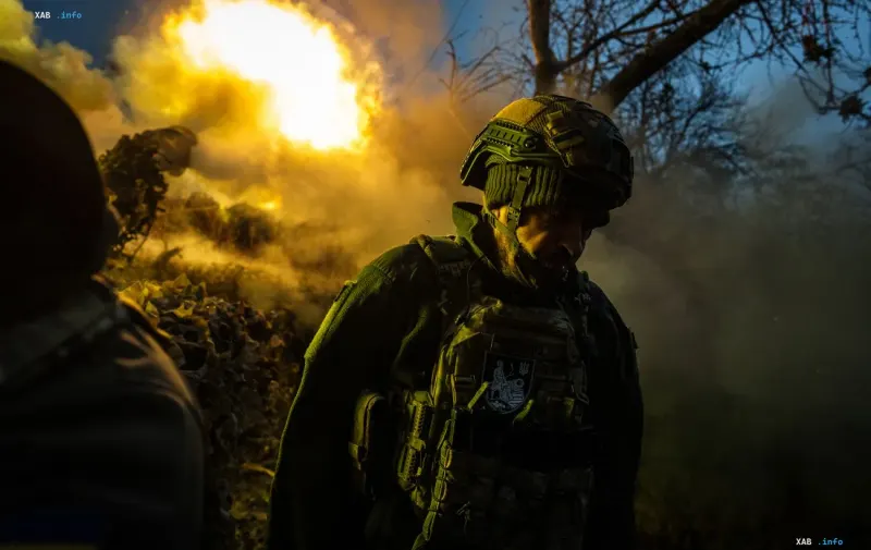 Военнослужащий ВСУ в защитной экипировке на фоне взрыва и дыма на фронте