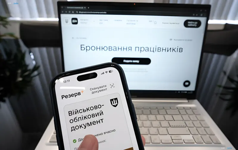 Smartphone mit Reserve+-App vor Laptop-Bildschirm mit Diia-Portal