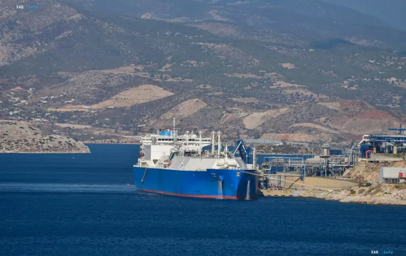 Blauer Öltanker liegt vor einer bergigen Küstenlandschaft am Terminal