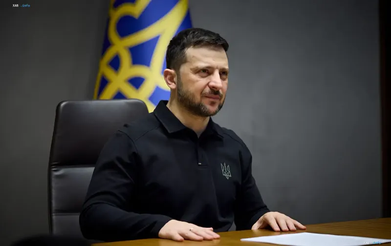 Der ukrainische Präsident Wolodymyr Selenskyj in einem schwarzen T-Shirt sitzt während einer Ansprache am Tisch.