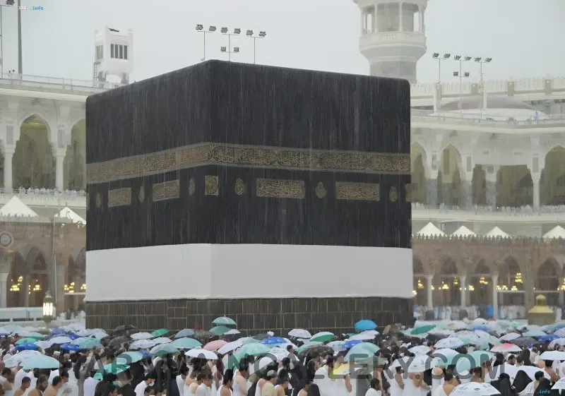 Die Kaaba in Mekka bei strömendem Regen mit einer Menschenmenge von Pilgern unter Regenschirmen