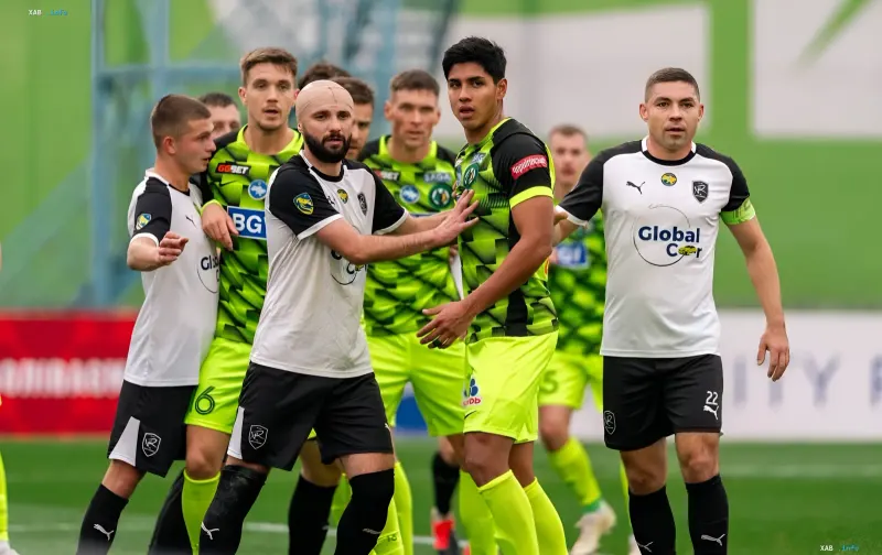 Football players in black-and-white and green-and-black kits during a Ukrainian Cup match
