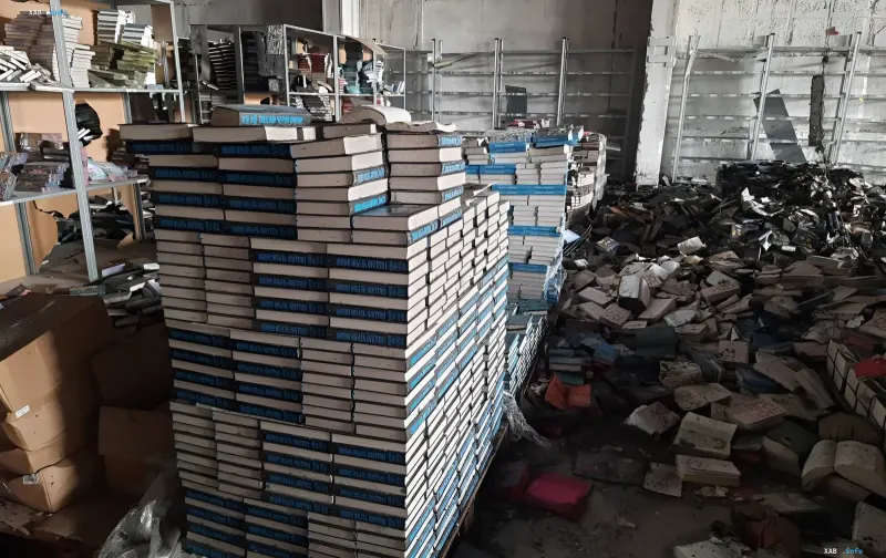 Zerstörtes Lager mit Bücherstapeln und Haufen von Druckerzeugnissen nach Beschuss