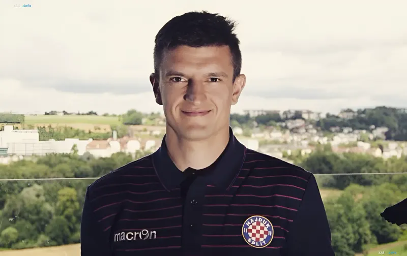 Ukrainian footballer Maksym Bilyi smiling in a dark striped polo shirt with a club crest