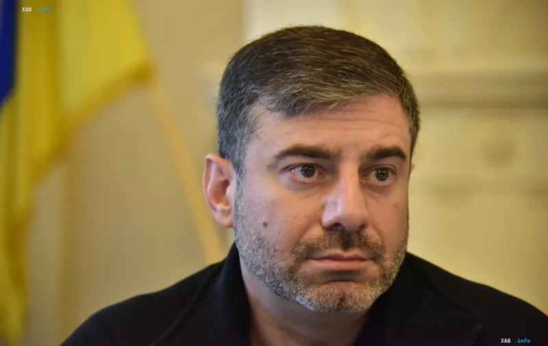 Ukrainian Ombudsman Dmytro Lubinets speaking in front of the national flag