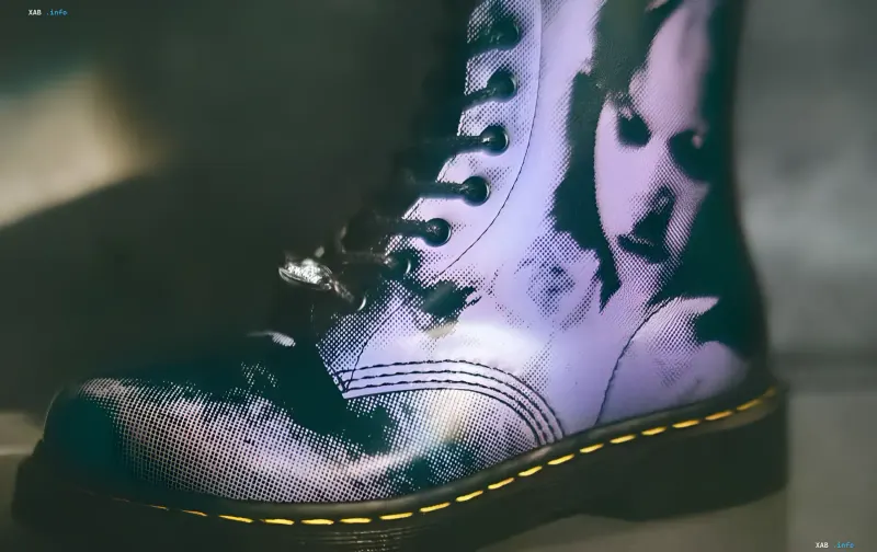 Schwarzer Dr. Martens Lederstiefel aus der Exorzist-Kollektion mit lila Print von Regans besessenem Gesicht