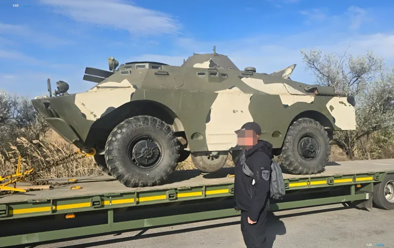 Sichergestelltes militärisches Gepanzerte Fahrzeug BRDM-2 im Tarnanstrich auf einem spezialisierten Tieflader