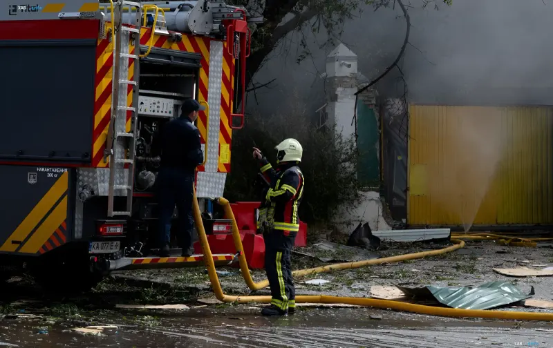 Fire engine and rescuers dealing with the aftermath of the nighttime strike on an enterprise in Kremenchuk