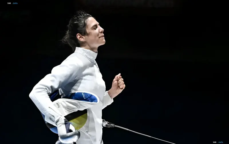 Ukrainian fencer Vlada Kharkova in a white suit celebrating her victory