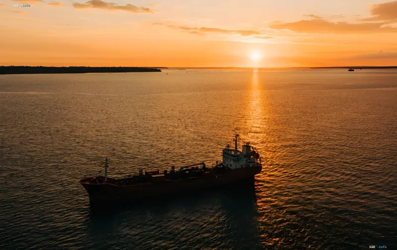 Öltanker fährt bei goldenem Sonnenuntergang auf dem Meer