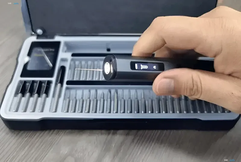 A hand holds the smart Arrowspace S1 electric screwdriver with a camera over an open bit case