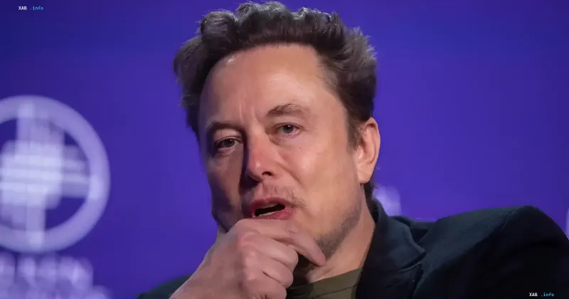 Elon Musk blickt nachdenklich und berührt mit der Hand sein Kinn während einer Konferenz
