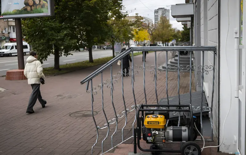 Stromerzeuger auf einer Straße in Kiew vor einem Gebäude mit Passanten während Stromausfällen
