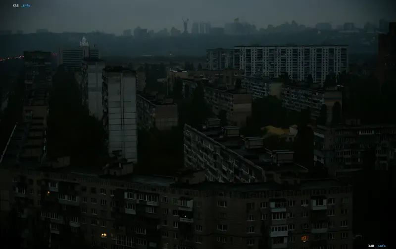 Panoramic view of a Kyiv residential district at dusk with apartment windows plunged into darkness due to power outages