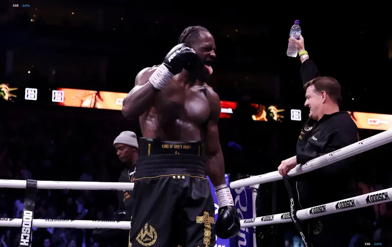 Deontay Wilder celebrating a victory inside the boxing ring with raised arms