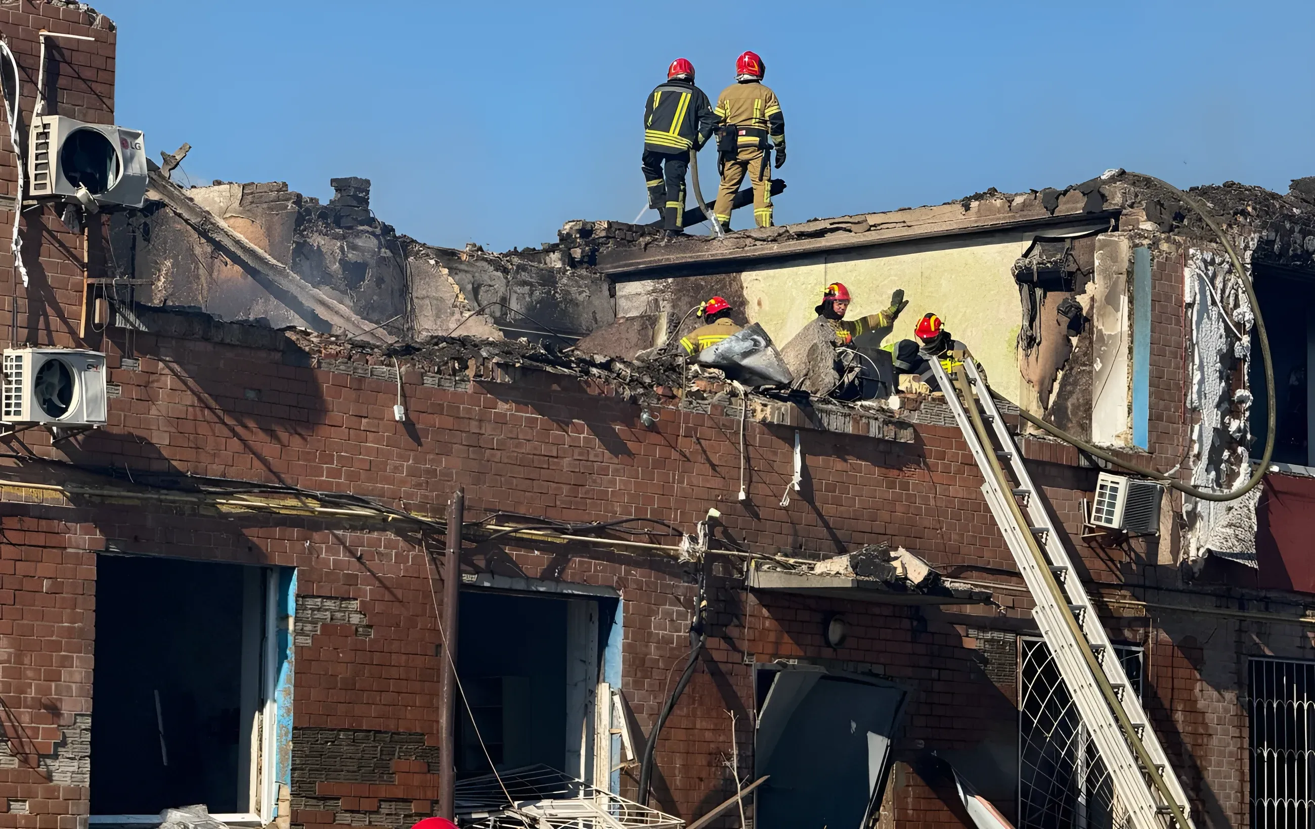 Пожарные тушат пожар в разрушенном здании после ракетного обстрела в Киеве