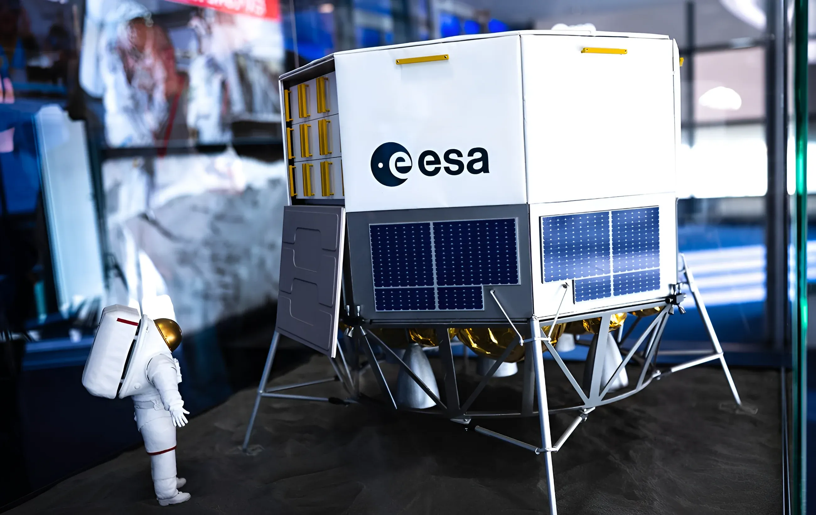 Макет космічного апарата з логотипом Європейського космічного агентства (ESA) та фігурка астронавта на виставці